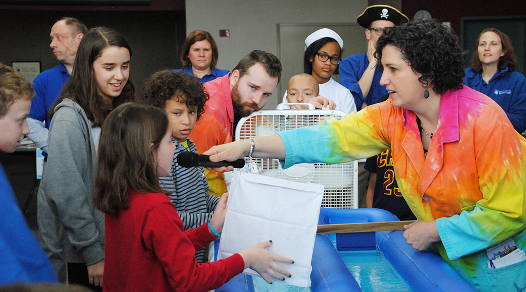 A group of children engage in scientific exploration at the Great Lakes Science Center.